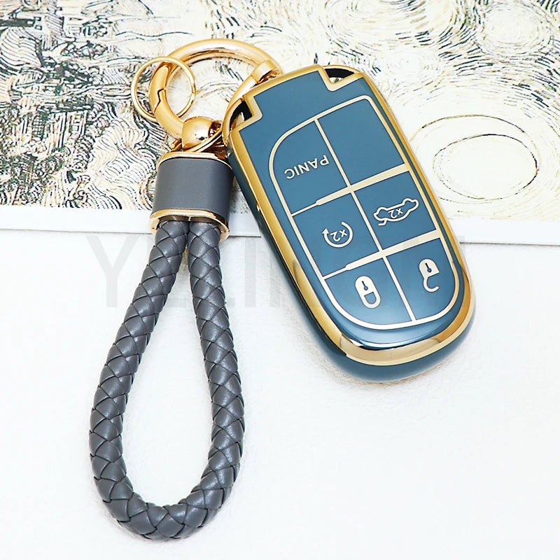 A blue TPU car key fob cover with a gold chain attached, resting on a piece of paper.