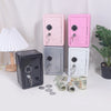 A collection of vintage metal piggy banks in pink, gray, and white, with coins and keys scattered nearby.