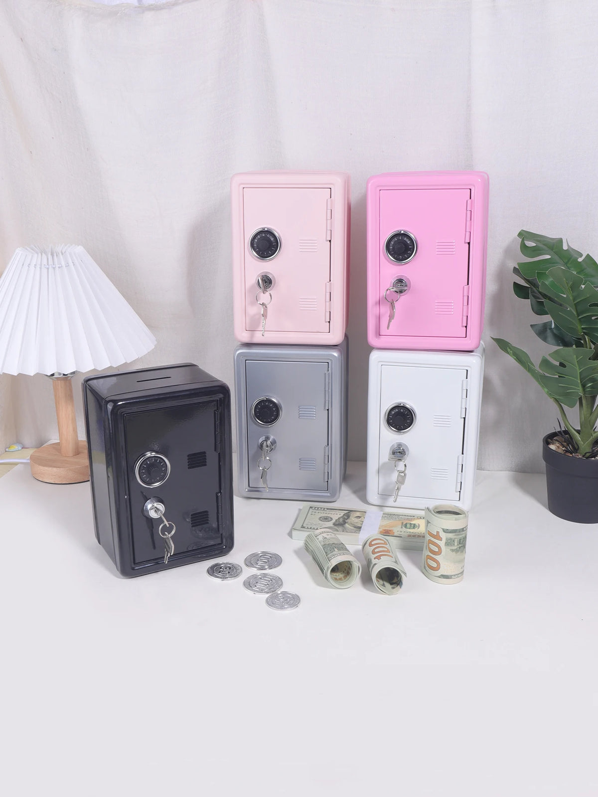 A collection of vintage metal piggy banks in pink, gray, and white, with coins and keys scattered nearby.
