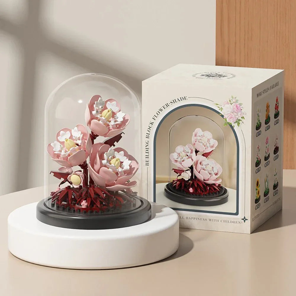 A white glass display of a pink rose bouquet is shown next to its original cardboard box.