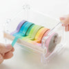 A hand is holding a colorful set of washi tape strips inside a clear plastic storage box.