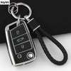 A silver TPU car key fob cover with a black strap is shown against a dark background.