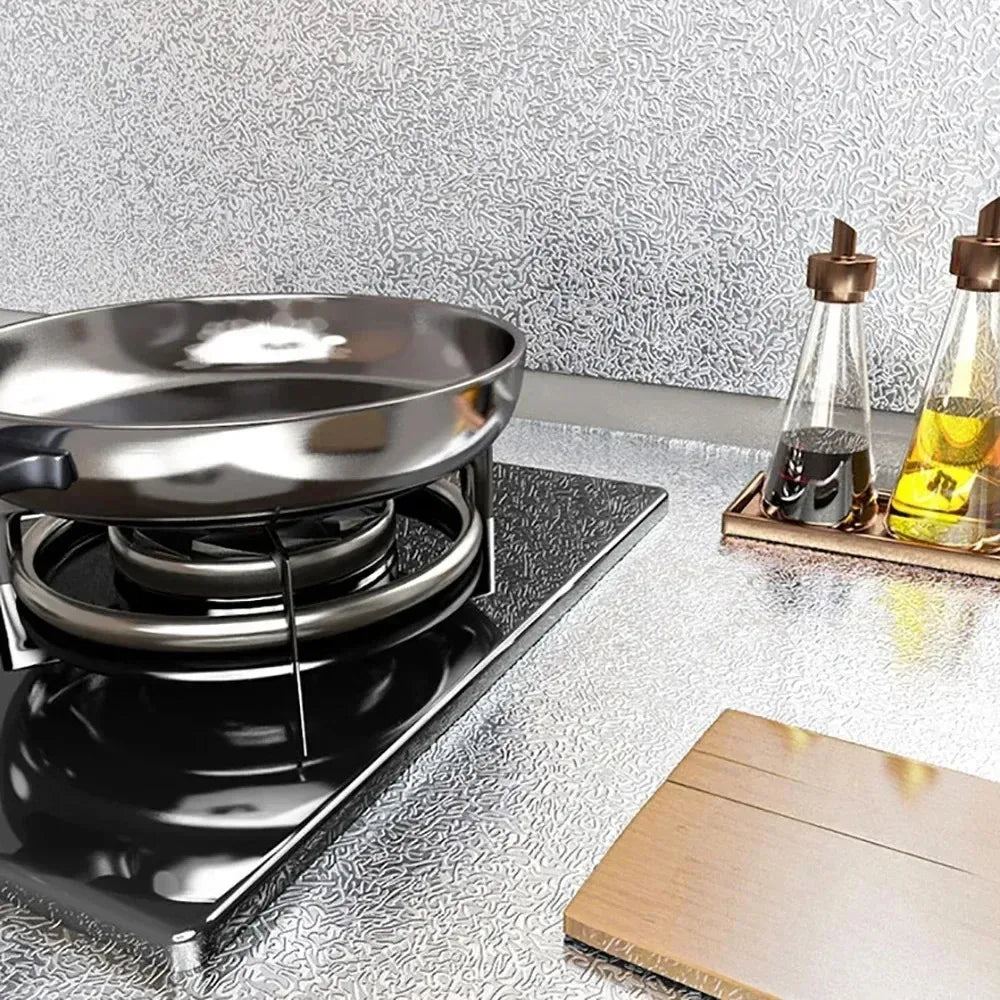 A black induction cooktop is shown next to glass bottles of oil on a textured surface.