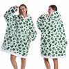 Eine Frau modelliert einen oversized Fleece-Hoodie mit grünem Leopardenmuster.