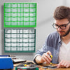 A man is working on a wooden table with a green wall-mounted parts organizer and various tools.