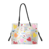 A clear plastic tote bag with black handles and an inner pouch filled with heart-shaped confetti.