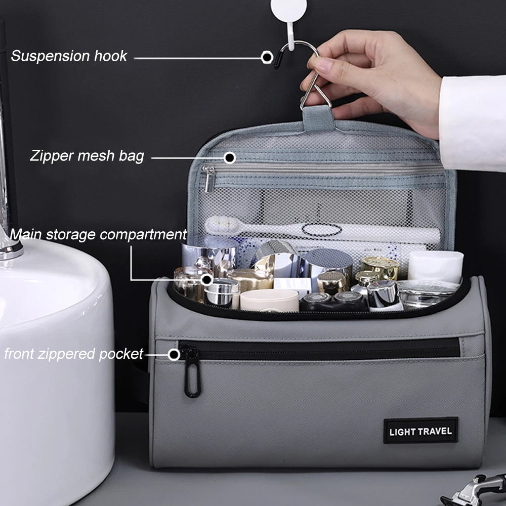 A gray toiletry bag is shown open, displaying a zipper mesh bag and a front zippered pocket, with a hand attaching a suspensi