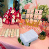 Pink and gold party display featuring white organza drawstring bags for gifts and party favors