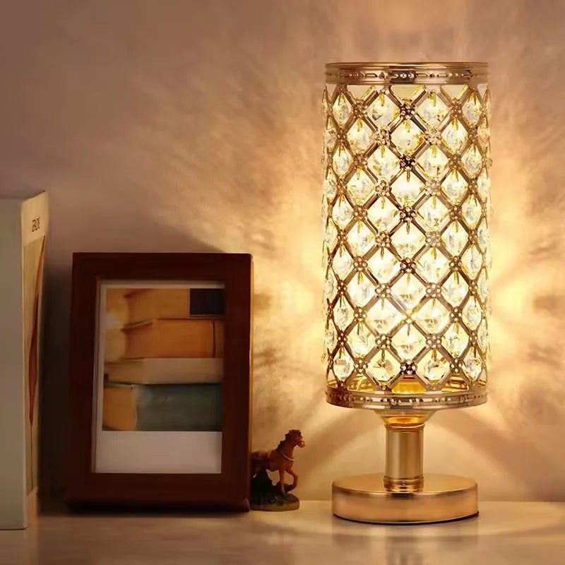 A modern crystal touch-sensor table lamp with USB charging ports sitting on a wooden surface.