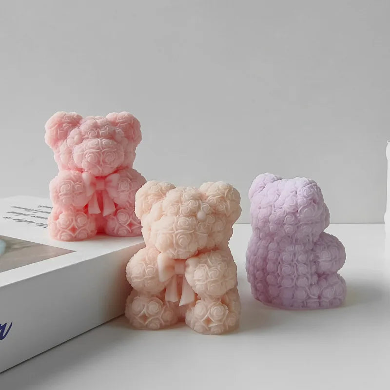 Three pink and purple silicone bear molds for DIY crafts displayed on a white surface.