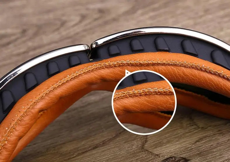 Close-up of an orange leather retro foldable motorcycle goggle with a silver frame and black padding.