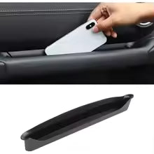 A white custom-fit windshield sunshade is being placed into a vehicle's interior vent.