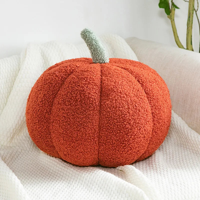 An orange, fuzzy Halloween pumpkin plush pillow resting on a white linen fabric.