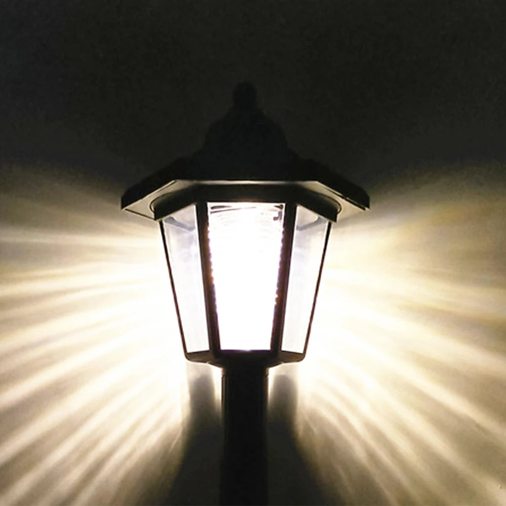 A solar-powered LED wall light shining a bright beam of light against a dark background.