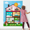 A girl points at a colorful felt story busy board depicting a house interior with various objects and farm animals.