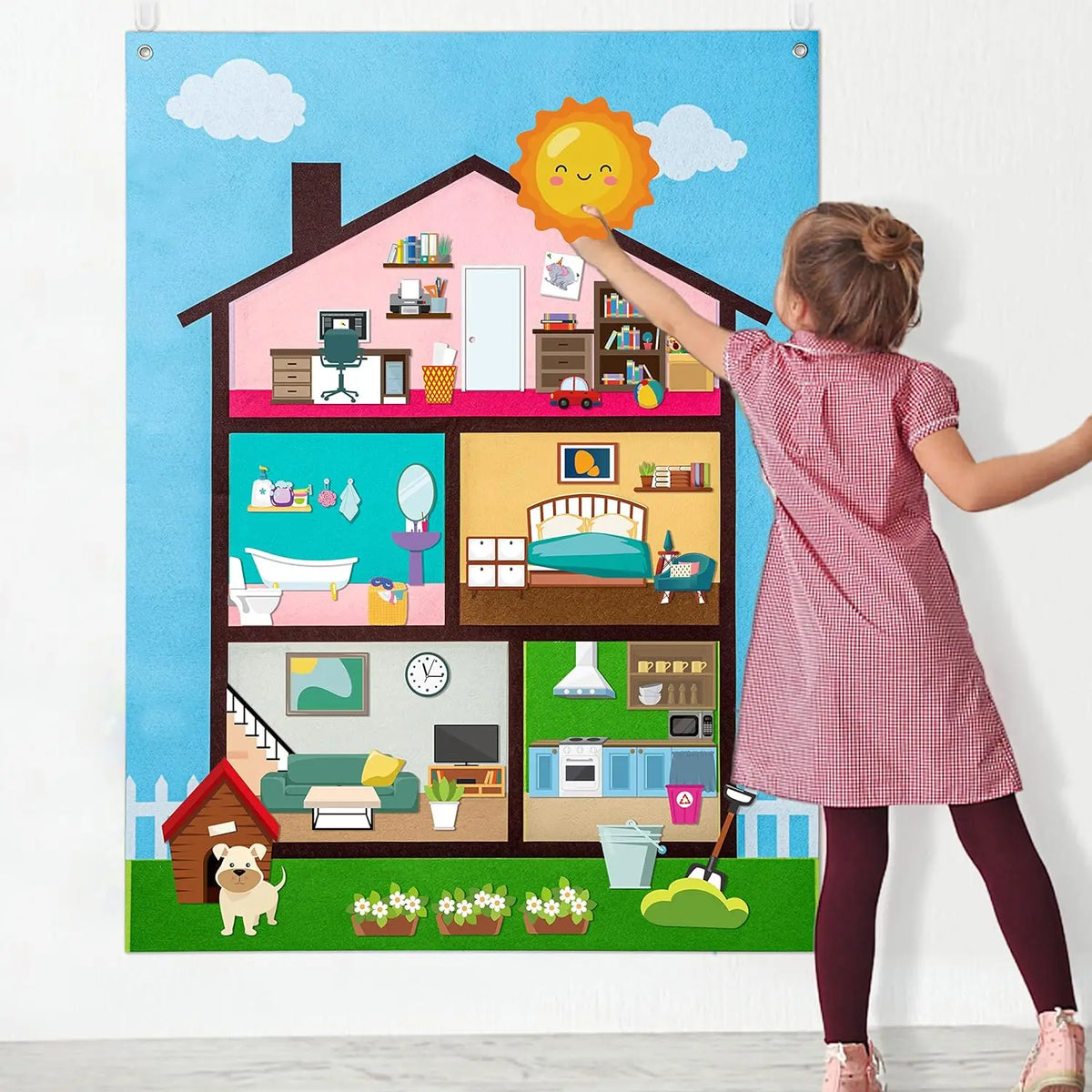 A girl points at a colorful felt story busy board depicting a house interior with various objects and farm animals.
