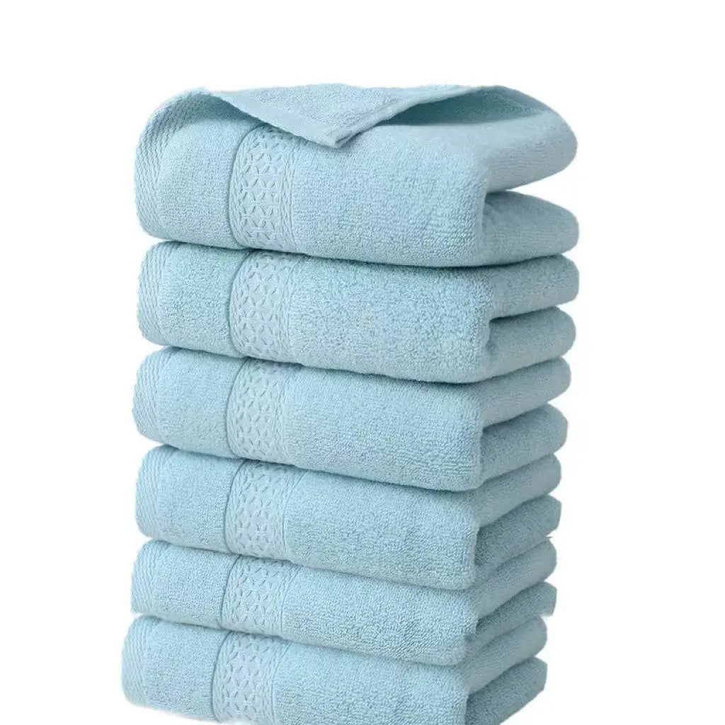 A stack of six light blue, textured cotton face towels.