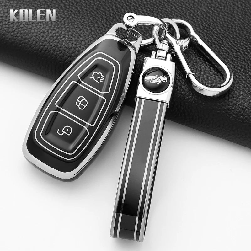 A black silicone car key fob cover with a silver keychain attached, resting on a black fabric surface.