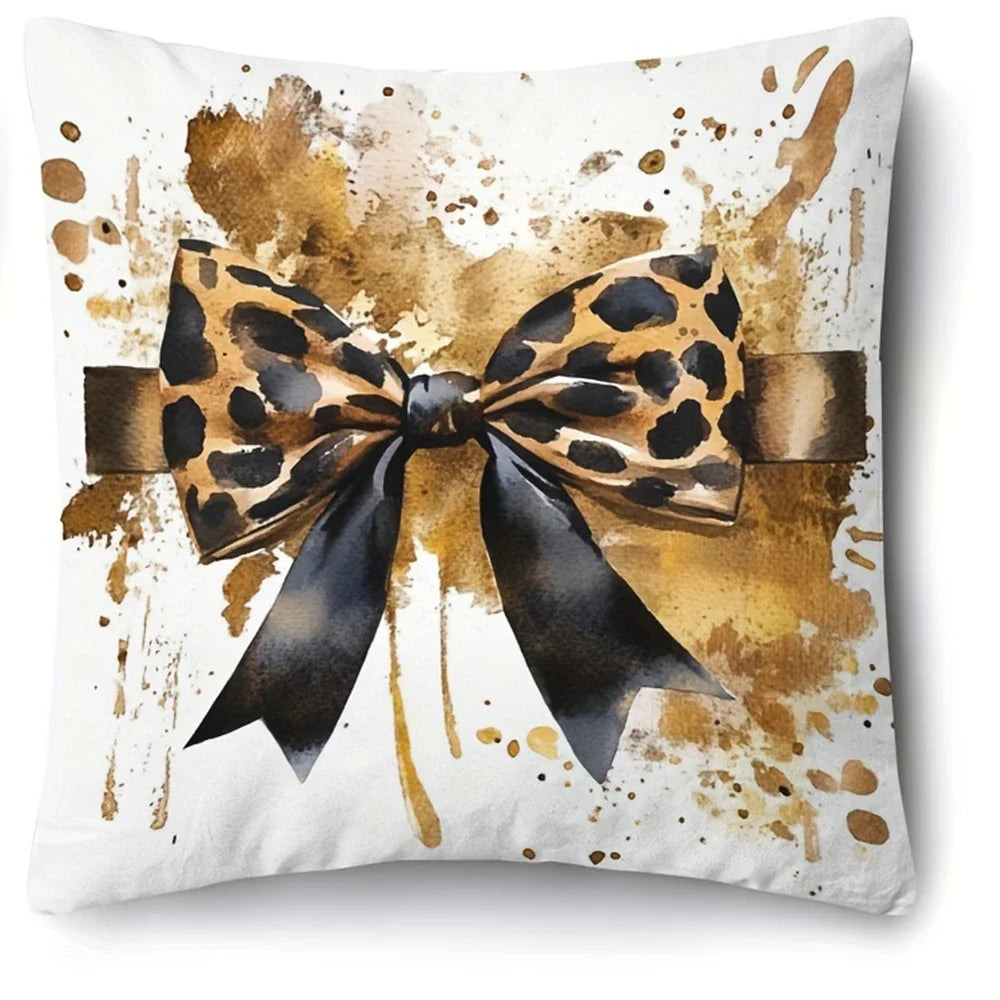 A decorative pillowcase featuring a leopard print bow design with gold and brown watercolor splashes on a white background.