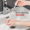 A hand is using a flexible drain cleaning brush to clear a clog in a sink.