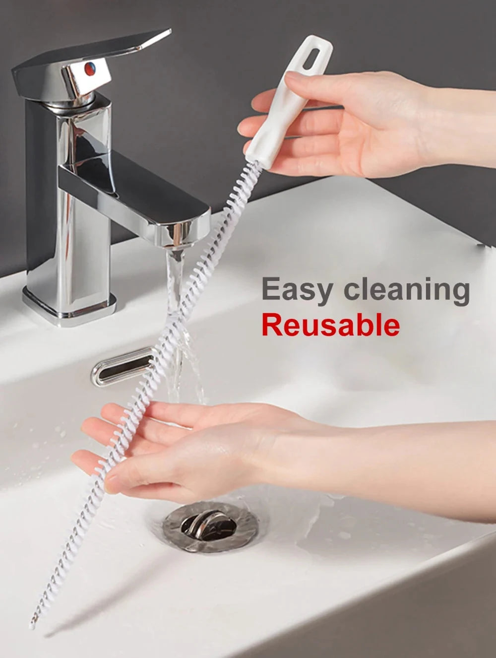 A hand is using a flexible drain cleaning brush to clear a clog in a sink.