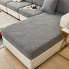 A gray stretch jacquard sofa cover featuring a leaf pattern on a modern sectional sofa.