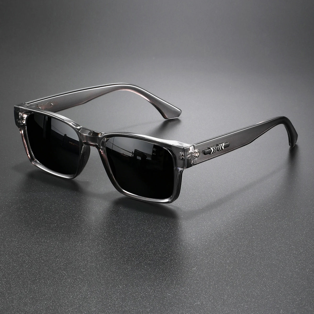 A pair of black retro square sunglasses with silver metal frames resting on a dark surface.