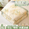 A stack of 100% silk quilted blankets in light green and cream colors for summer comfort