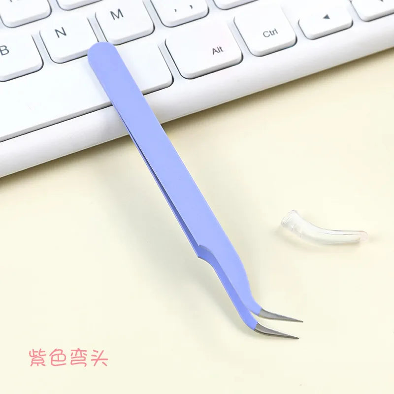 A light purple precision craft tweezers with straight and curved tips resting on a white keyboard.