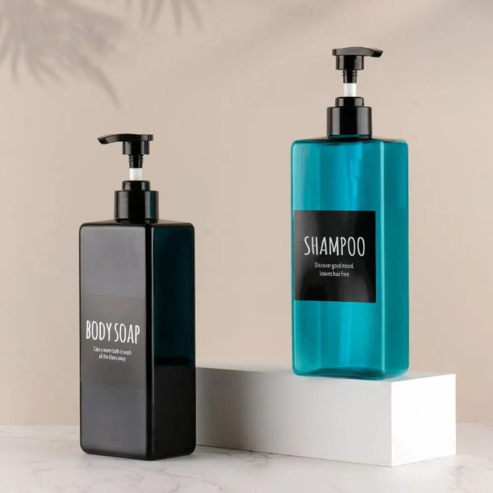 A set of three dark green and blue refillable soap dispenser bottles with black pump tops displayed on a white surface.