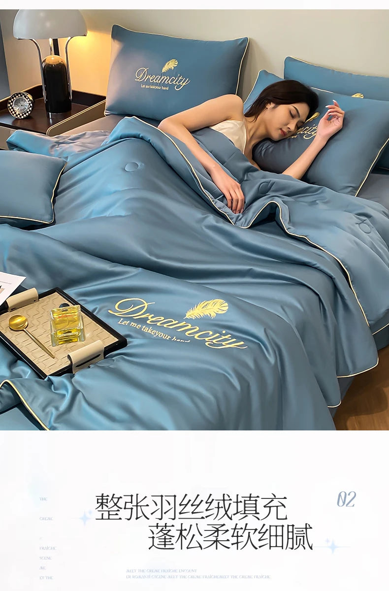 A woman rests on a blue comforter featuring the Dreamcity embroidery, highlighting the ultra-soft cooling fabric.