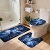 A set of three blue and white wolf designs non-slip bathroom mats placed in front of a white toilet.