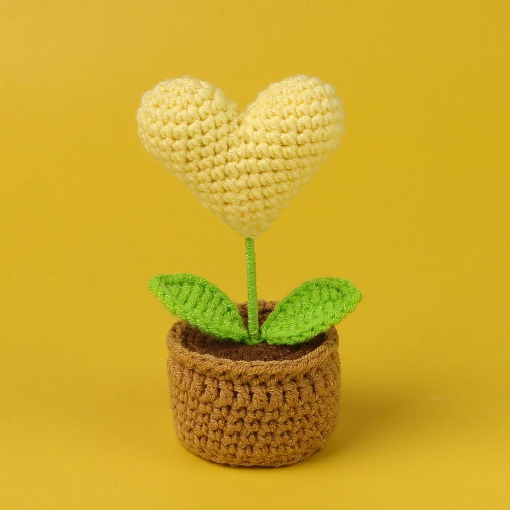 Handcrafted crochet heart flower growing in a pot of soil
