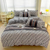 A black and white patterned bedding set featuring a duvet cover, fitted sheet, and pillows on a bed.