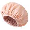 A large, pink satin-lined waterproof shower cap for hair protection shown from the side.