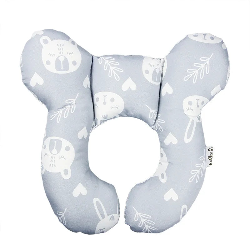 A light blue baby head and neck support pillow featuring cute animal faces and leaves.