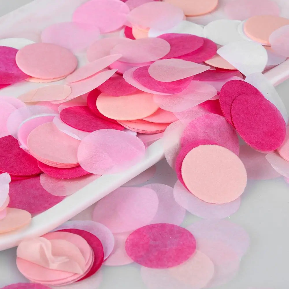 Gemischte rosa und magentafarbene Papiertaschentückchenstreu auf weißer Fläche