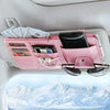 Pink car sun visor organizer holding sunglasses, a smartphone, and cash in multiple pockets.
