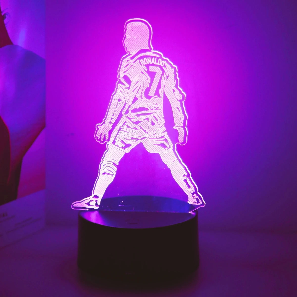 Leuchtende 3D-Touch-LED-Nachtleuchte in Form eines Fußballspielers im Trikot, beleuchtet mit violettem Licht.