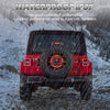 Rear view of a red Jeep Wrangler with an aftermarket spare tire brake light in snowy conditions.