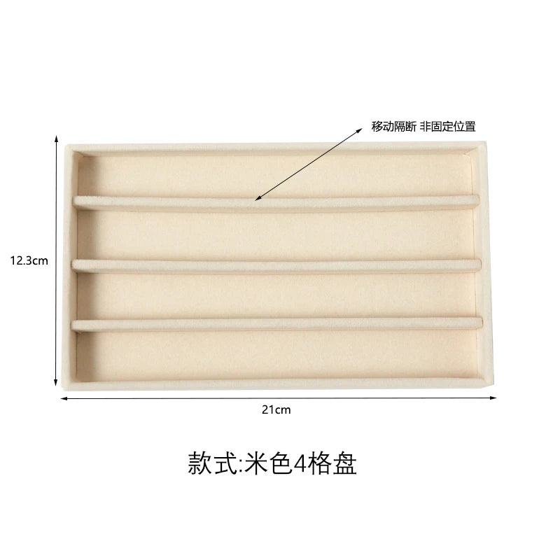 A light beige velvet jewelry organizer tray with four detachable compartments.