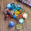 A collection of seven colorful polyhedral resin dice scattered on a wooden surface.