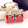 Gold-toned crystal rhinestone handbag keychain with a red leopard print detail.