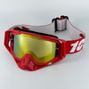 Red motorcycle goggles with yellow lenses and a gray strap are displayed on a white background.
