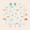 A white baby sensory tag comfort blanket featuring various dog and cat illustrations with colorful wooden tags.
