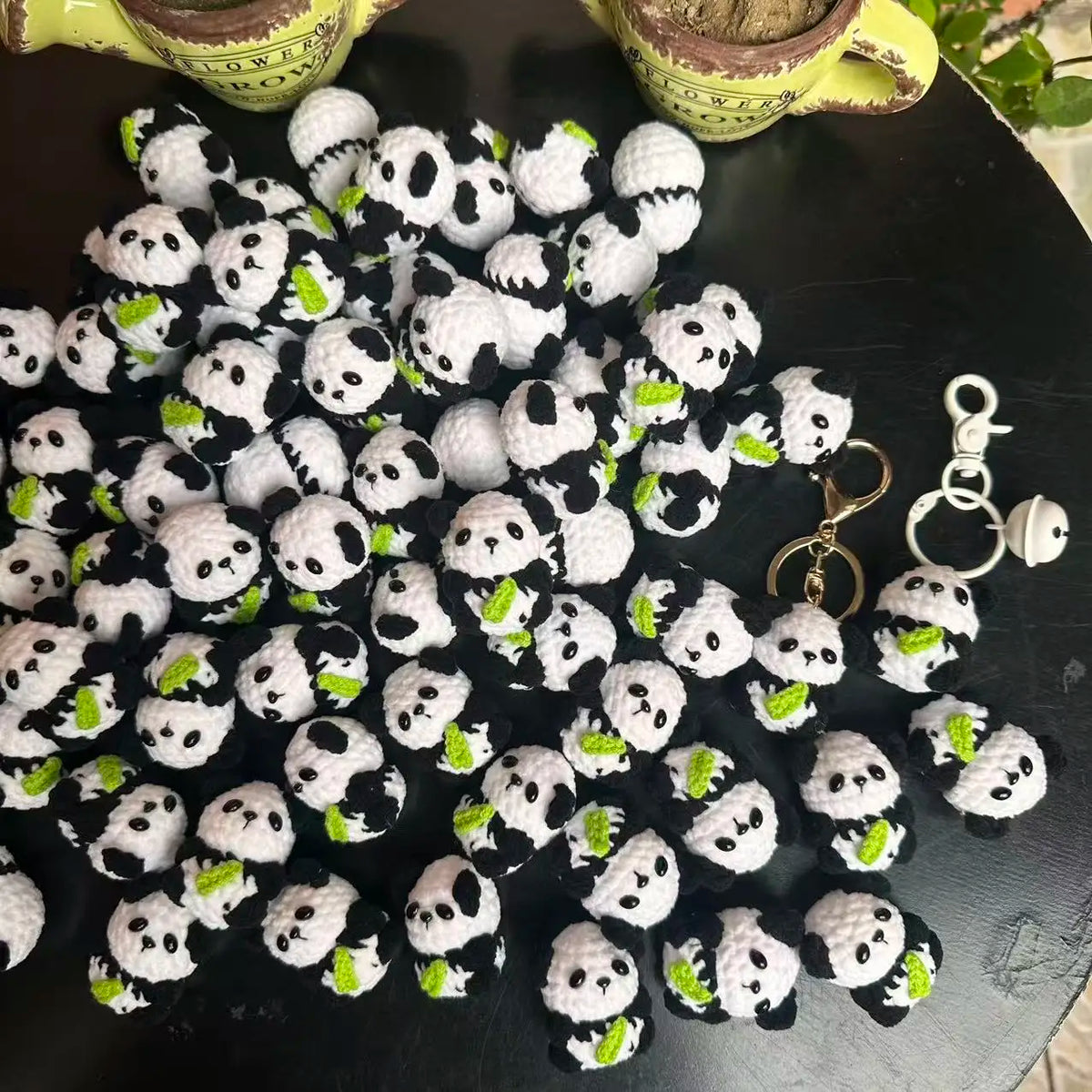 A pile of handmade crochet kitten keychains featuring cute panda and cartoon animal charms.