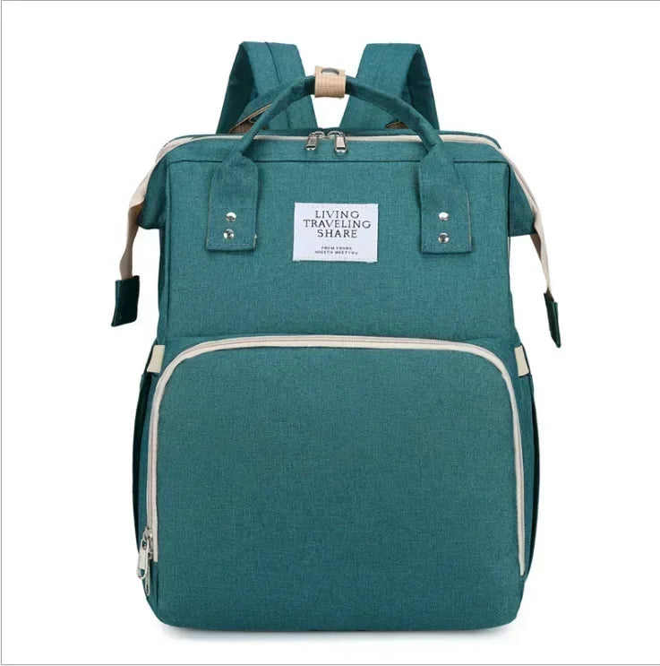 Teal backpack diaper bag with a light beige changing mat visible.