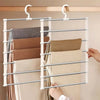 A silver multi-layer hanger displaying several folded trousers on a wooden rack.