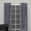 Gray fabric curtains hanging from a gold accent curtain rod in a window frame.