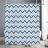 A white and blue chevron patterned shower curtain hanging on a metal rod in a bathroom setting.